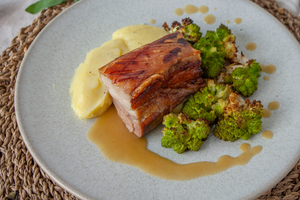 Confit pork belly served with buttery mash, roasted Romanesco cauliflower and apple & fennel sauce