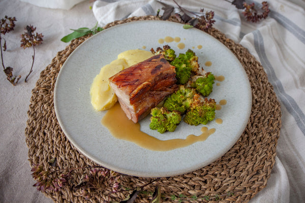 Confit pork belly served with buttery mash, roasted Romanesco cauliflower and apple & fennel sauce