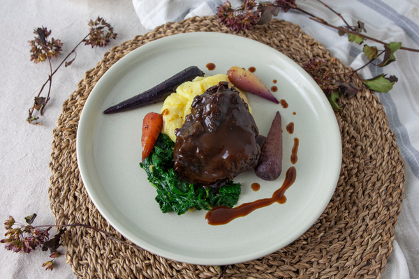 Braised Ox Cheek with wilted spinach, buttery mash potato and rainbow chantenay carrots, drizzled with a rich jus