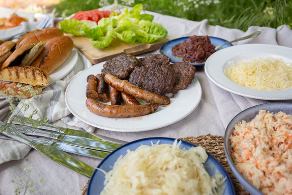 Wild boar sausages sausages and old cow burgers served with brioche buns, finger rolls, apple and carrot slaw, onions and cabbage toppings, grated gruyere cheese and fresh lettuce and tomatoes