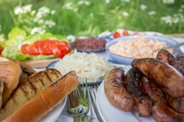Wild boar sausages sausages and old cow burgers served with brioche buns, finger rolls, apple and carrot slaw, onions and cabbage toppings, grated gruyere cheese and fresh lettuce and tomatoes